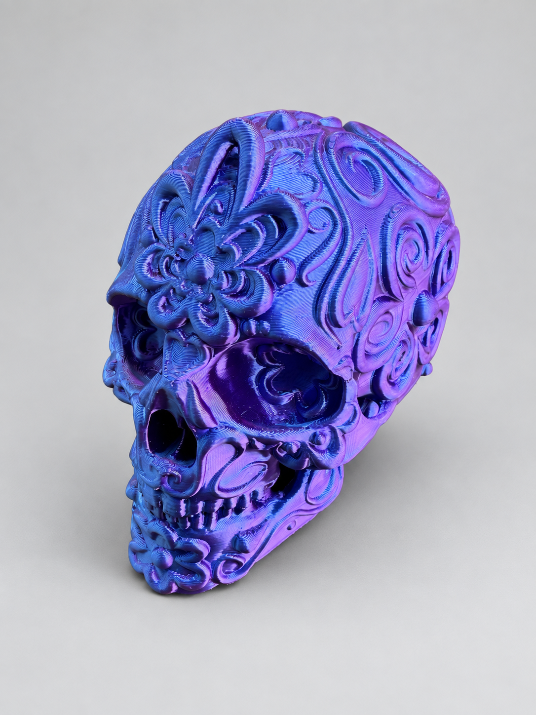 Candy skull ornament in Metallic Blue/Purple on a soft grey studio background