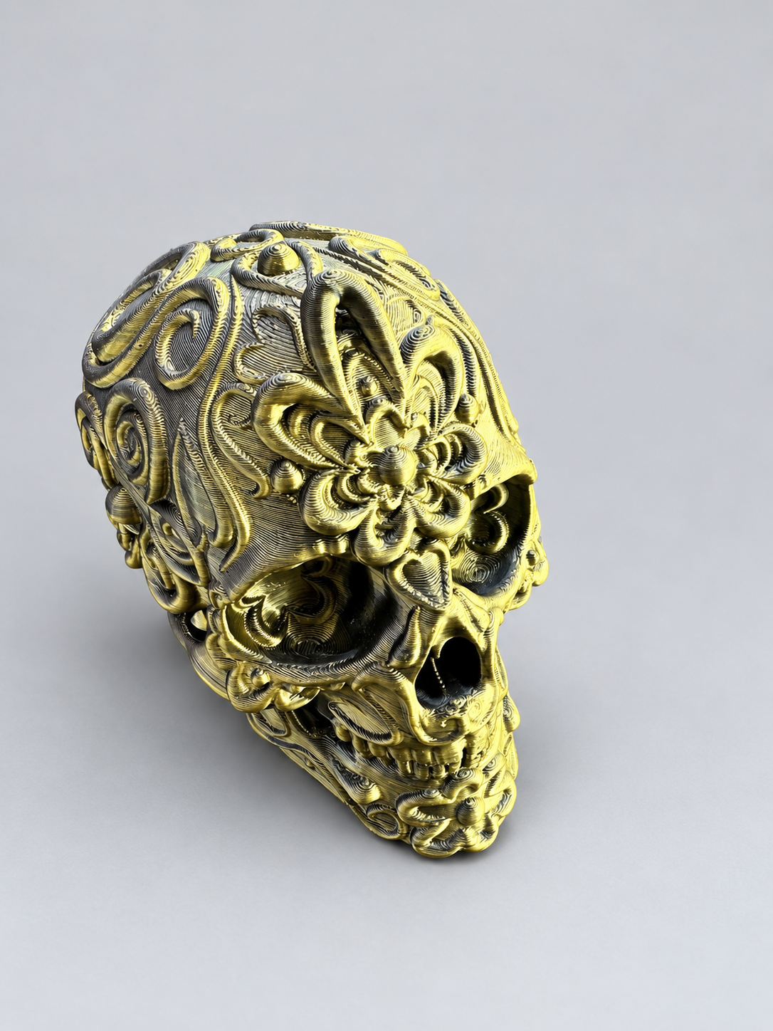 Candy skull ornament in Metallic Gold/Black on a soft grey studio background