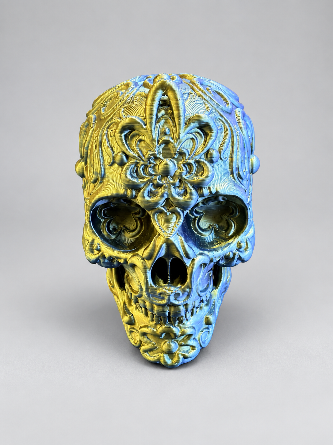Candy skull ornament in Metallic Gold/Blue on a soft grey studio background