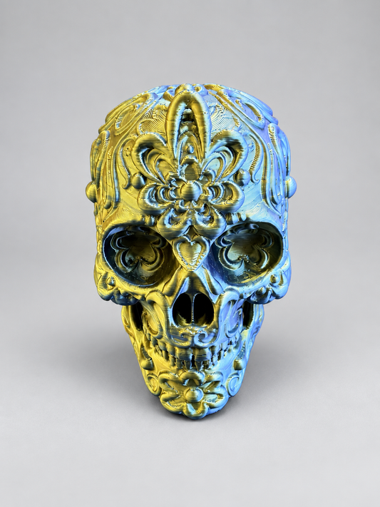 Candy skull ornament in Metallic Gold/Blue on a soft grey studio background