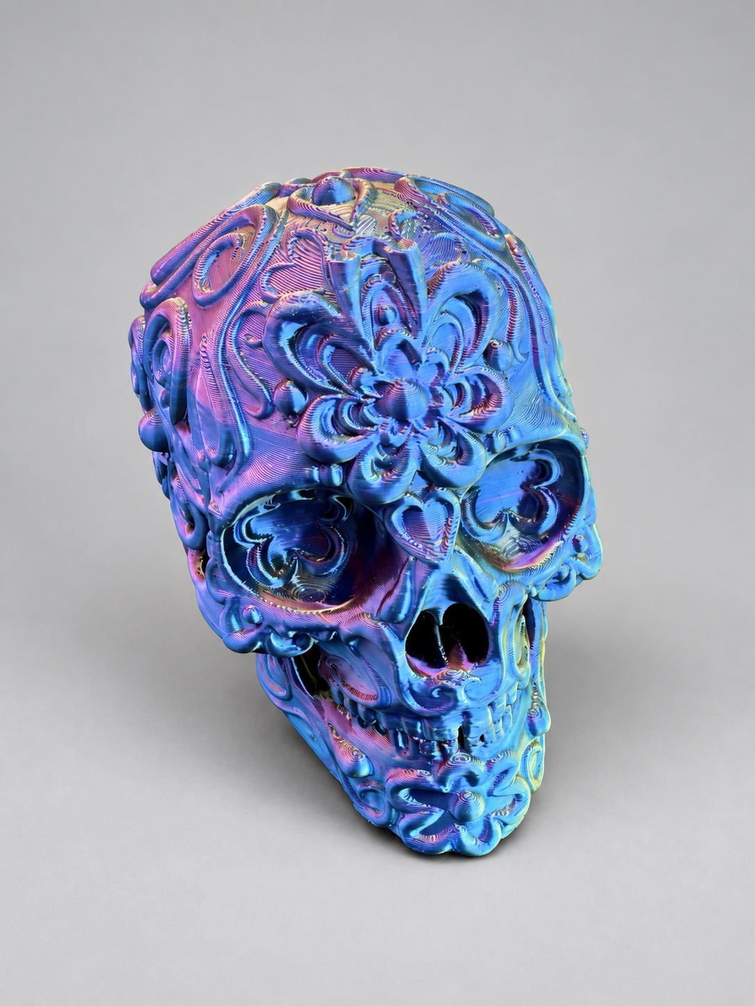 Candy skull ornament in Metallic Gold/Purple/Blue on a soft grey studio background