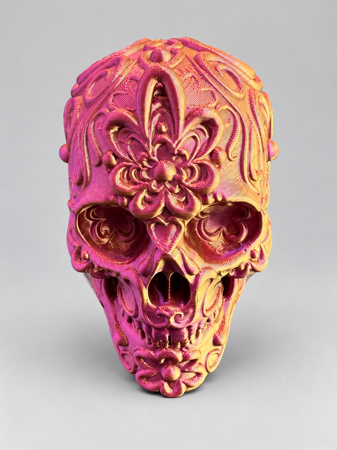 Candy skull ornament in Metallic Gold/Purple/Red on a soft grey studio background