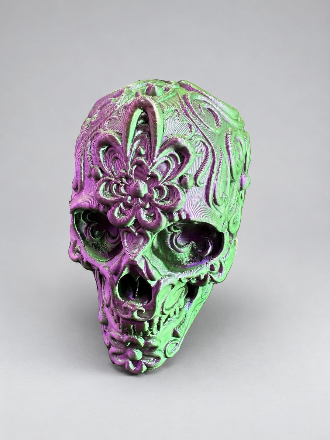Candy skull ornament in Metallic Green/Purple on a soft grey studio background