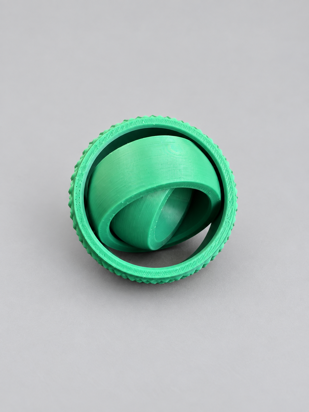 Green fidget gyro spinner opened to show rotating rings