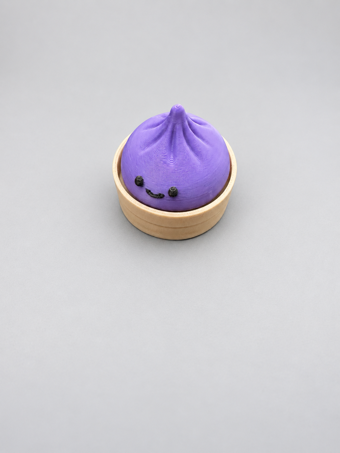 Purple dumpling clicker with smiling face and circular base