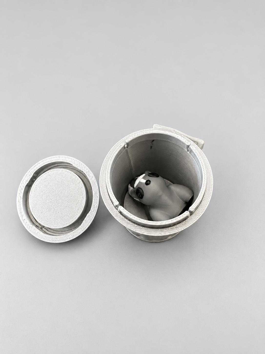 Articulated skunk tucked inside the open silver bin